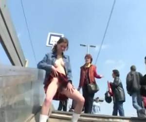 Polonahá dívka stojí čurat na veřejnosti. uprostřed schodů vlaku stanice umožňuje močit jim ženy slovem adresované její chování. polonahá dívka stojí čurat na veřejnosti
